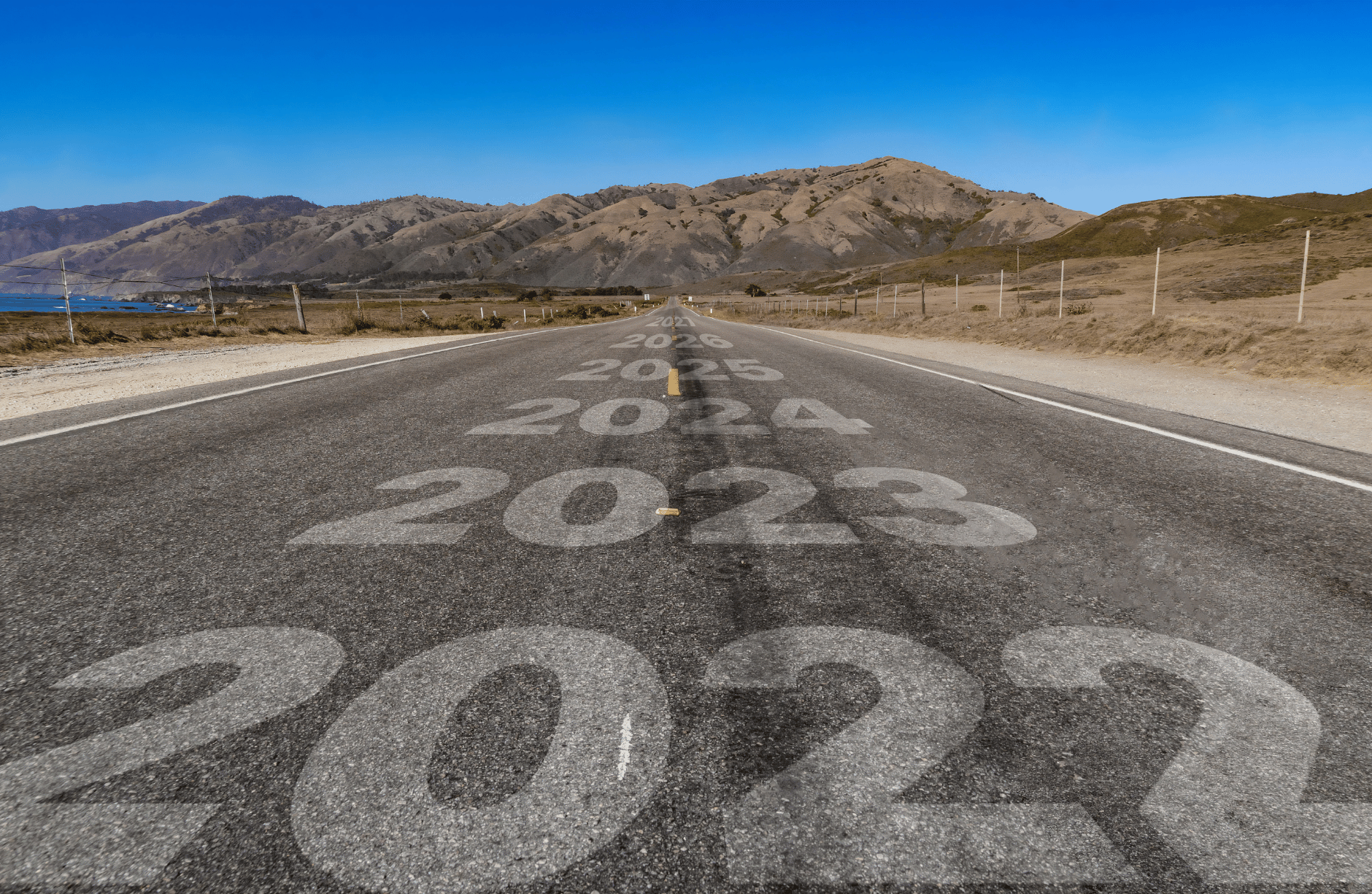 A Straight road leading into the distance and painted with years from 2022 onwards